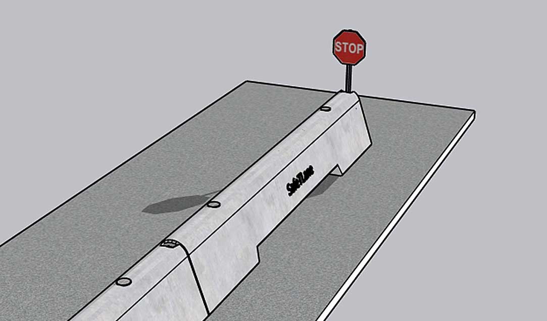 A concrete barrier blocks a road, with a stop sign posted at the end of the barrier. The scene is simple and set against a plain gray background.