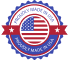 A circular badge with a blue scalloped edge and a red ribbon, featuring a stylized American flag in the center. Text on the badge reads “PROUDLY MADE IN USA.”.