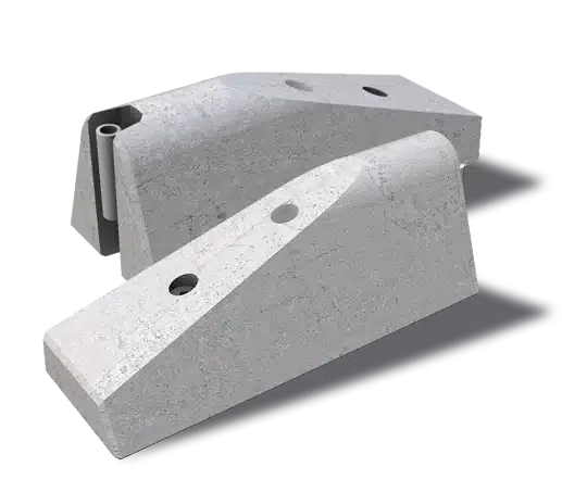 Two concrete wheel stops with angled faces and holes for securing, positioned side by side on a flat surface, casting shadows to the right.